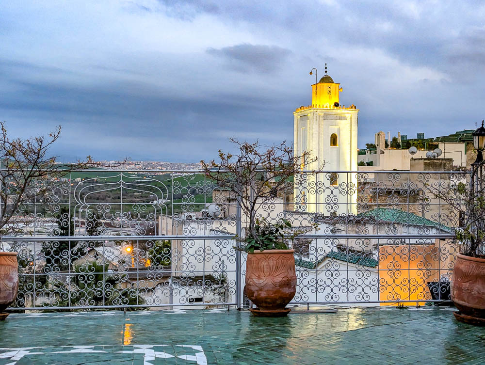 yellow lights on a mosque behind a green terrace