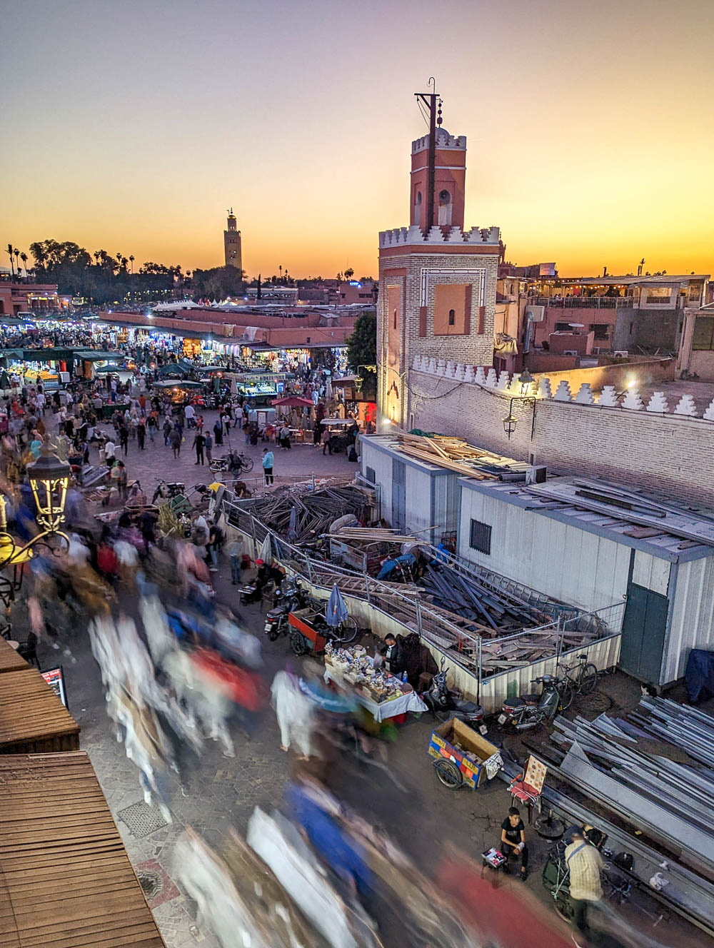 two mosques at sunset with lots of people walking around them