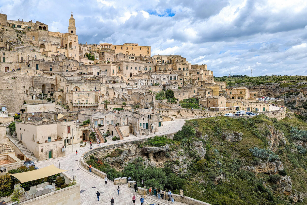 view of the beige stone city on a hill with a church on top