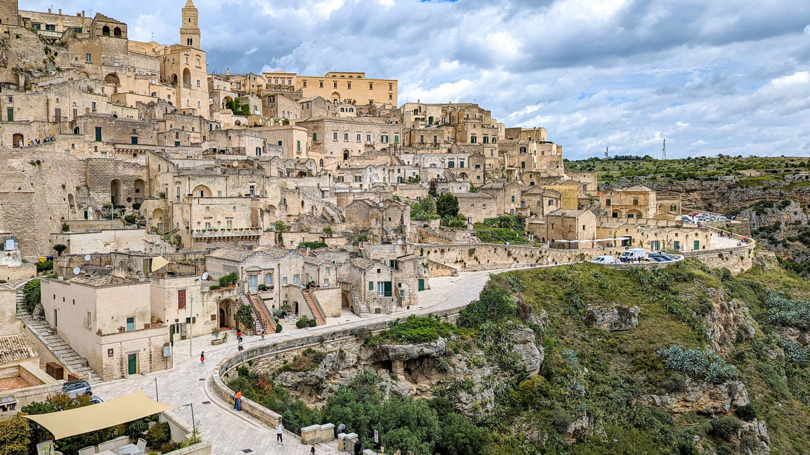 view of the beige stone city on a hill with a church on top