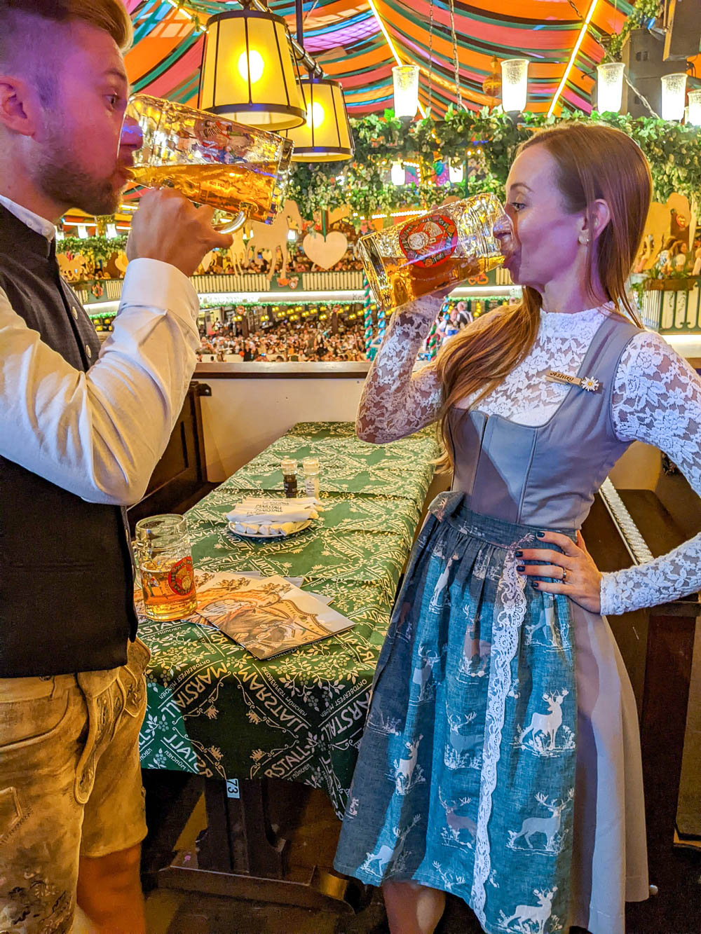 man and woman drinking beer inside a beer tent