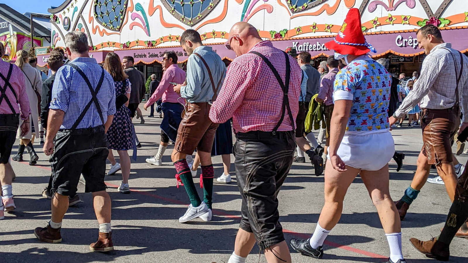 group of men walking through oktoberfest and one of them is wearing a diaper