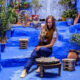 woman pouring tea in a blue courtyard