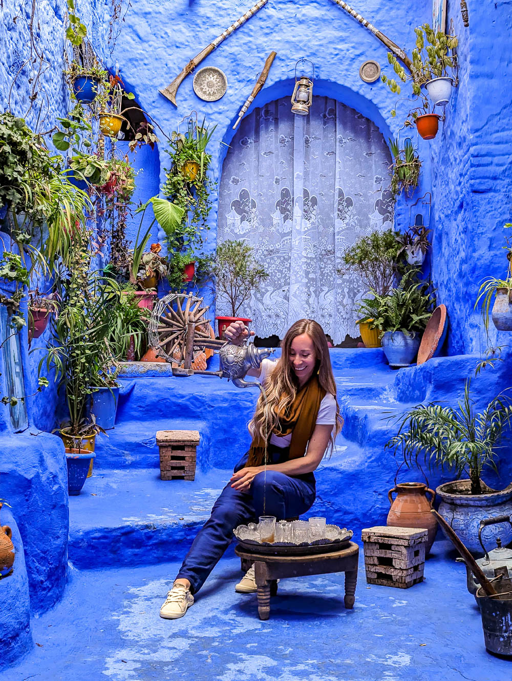 woman pouring tea on a blue patio