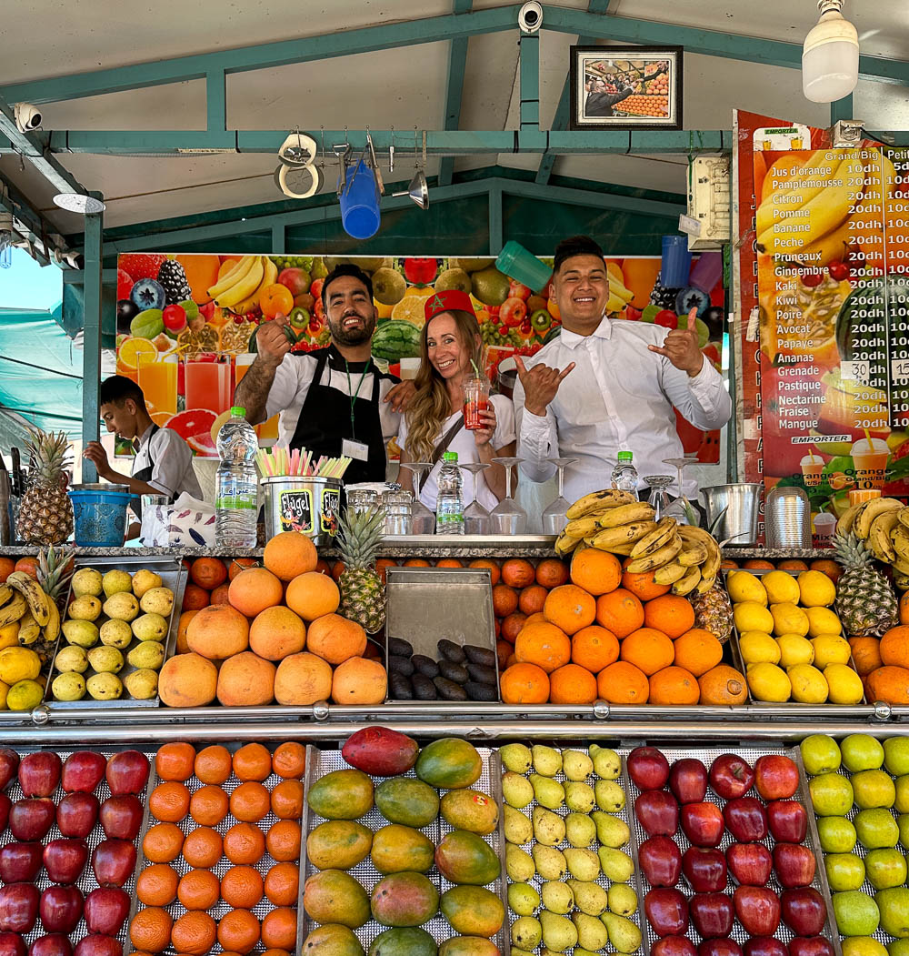 woman and two men smiling from behind a juice booth