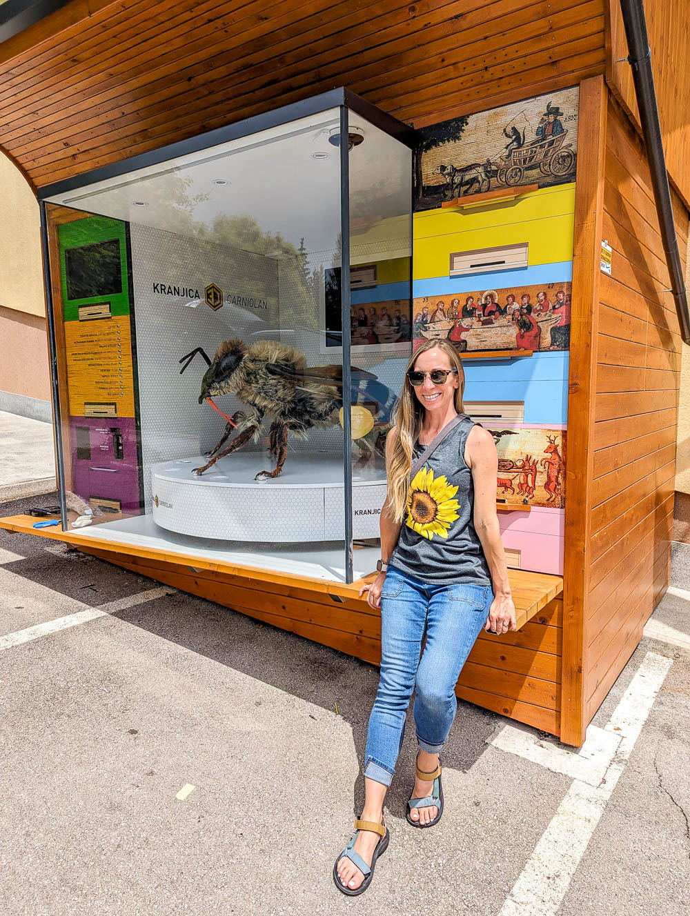 me in a sunflower shirt standing next to a giant model honeybee