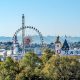 view of oktoberfest beer tents and ferris wheel with alps in the background