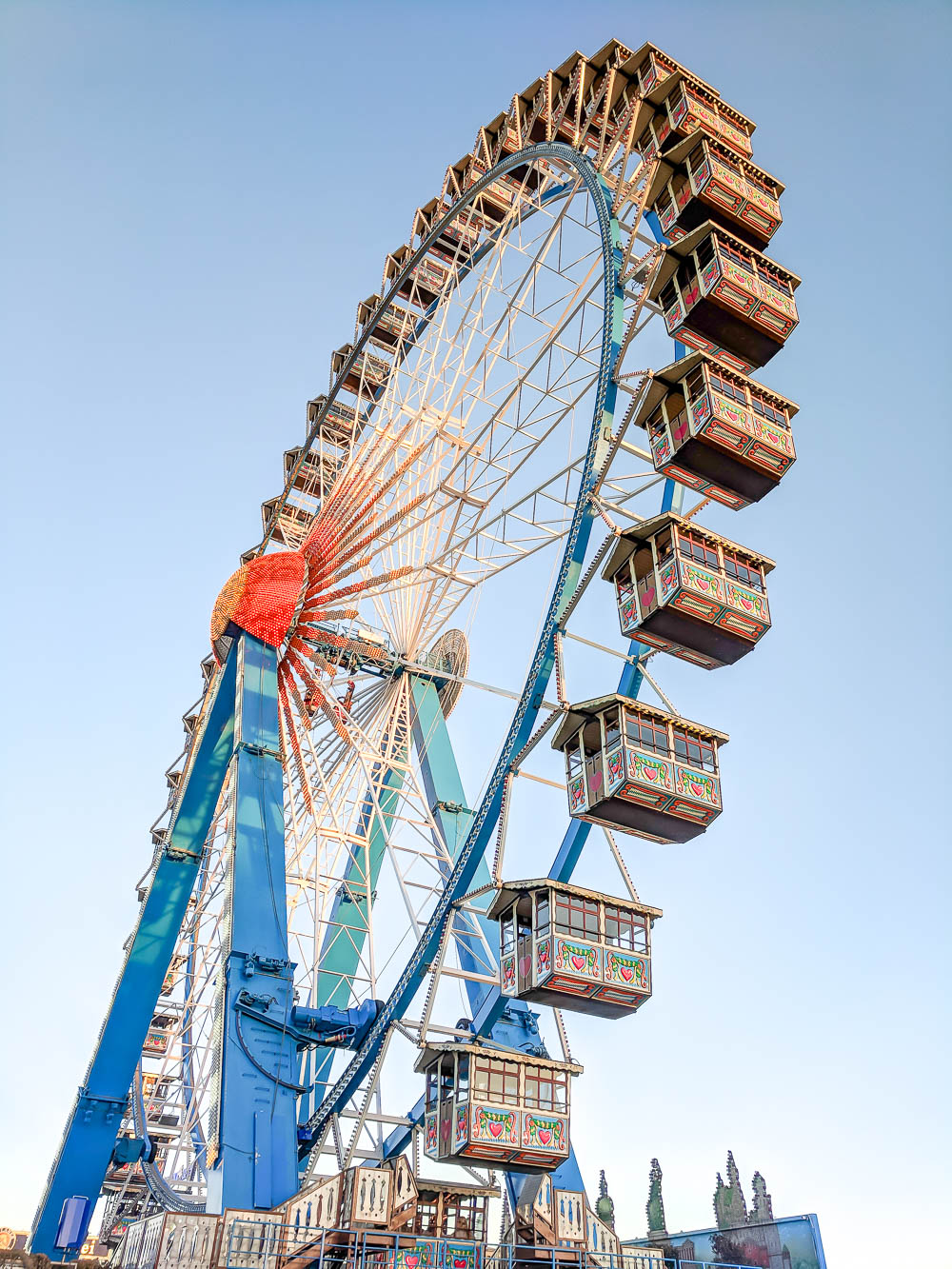 looking up at a big ferris wheel under a blue sky