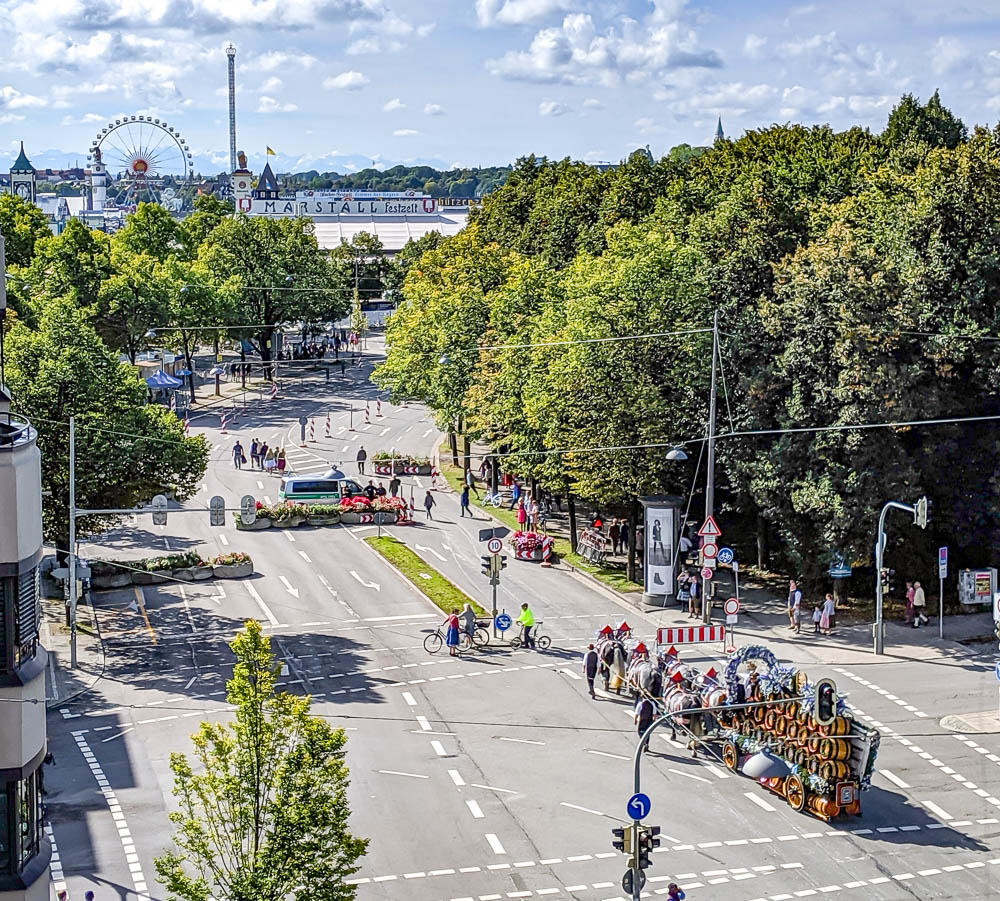 horse-drawn beer carriage making its way down the street towards oktoberfest in the morning