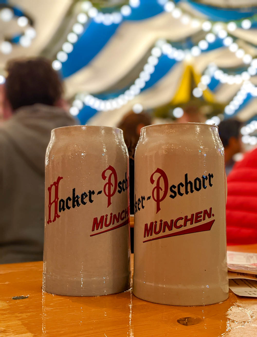 two stone beer mugs under a ceiling with lights and blue streamers