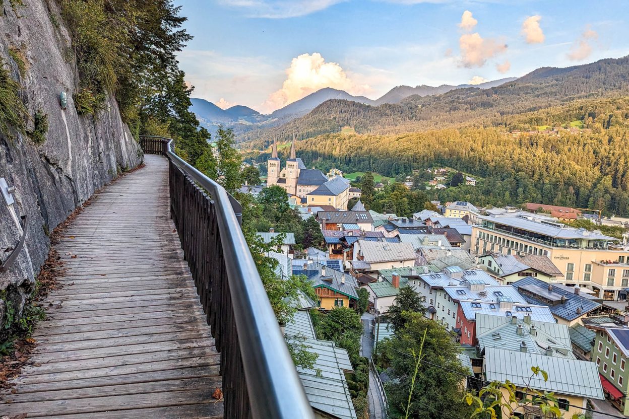 colorful town beneath a wooden walkway on the edge of a mountain