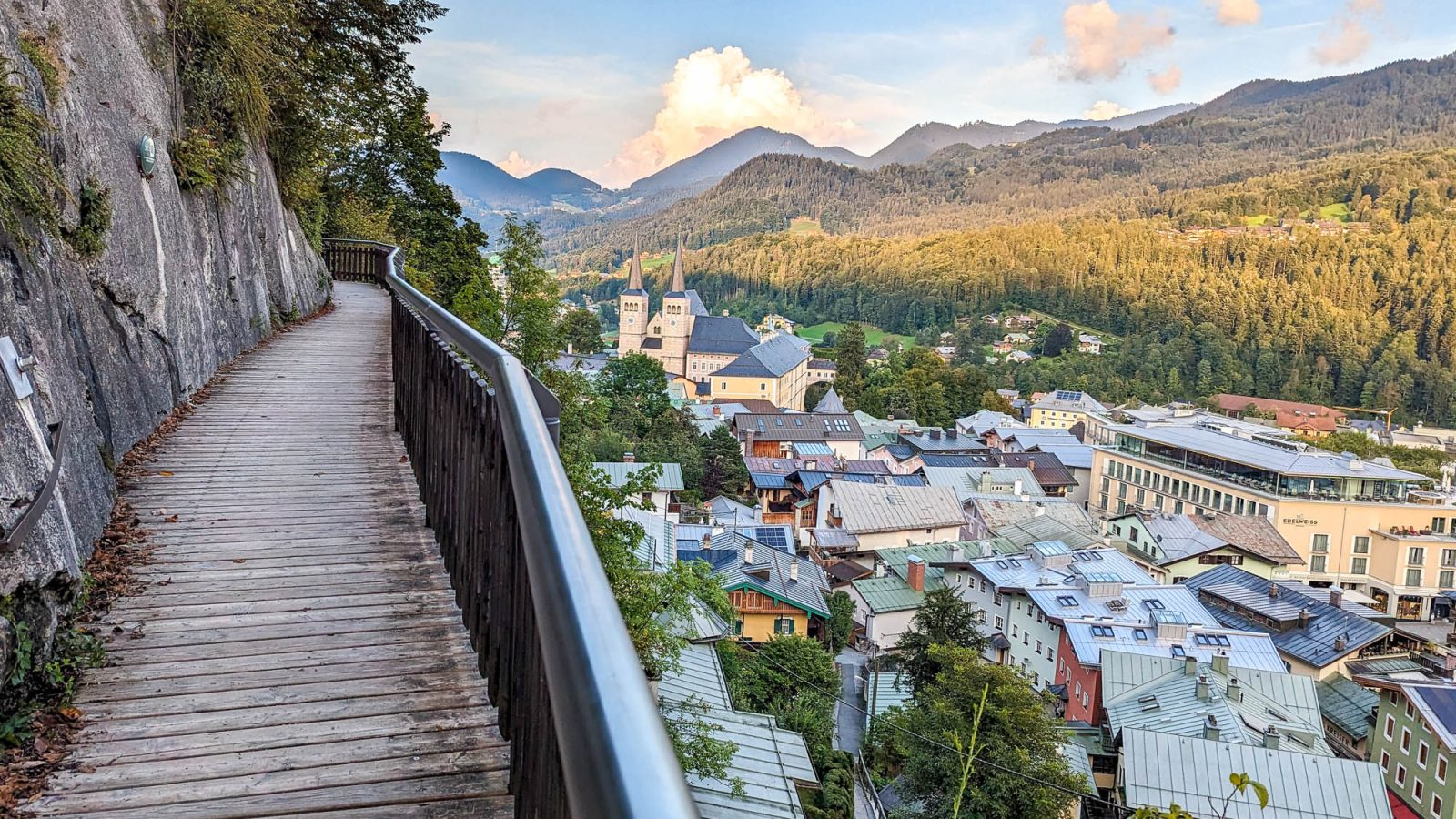 colorful town beneath a wooden walkway on the edge of a mountain