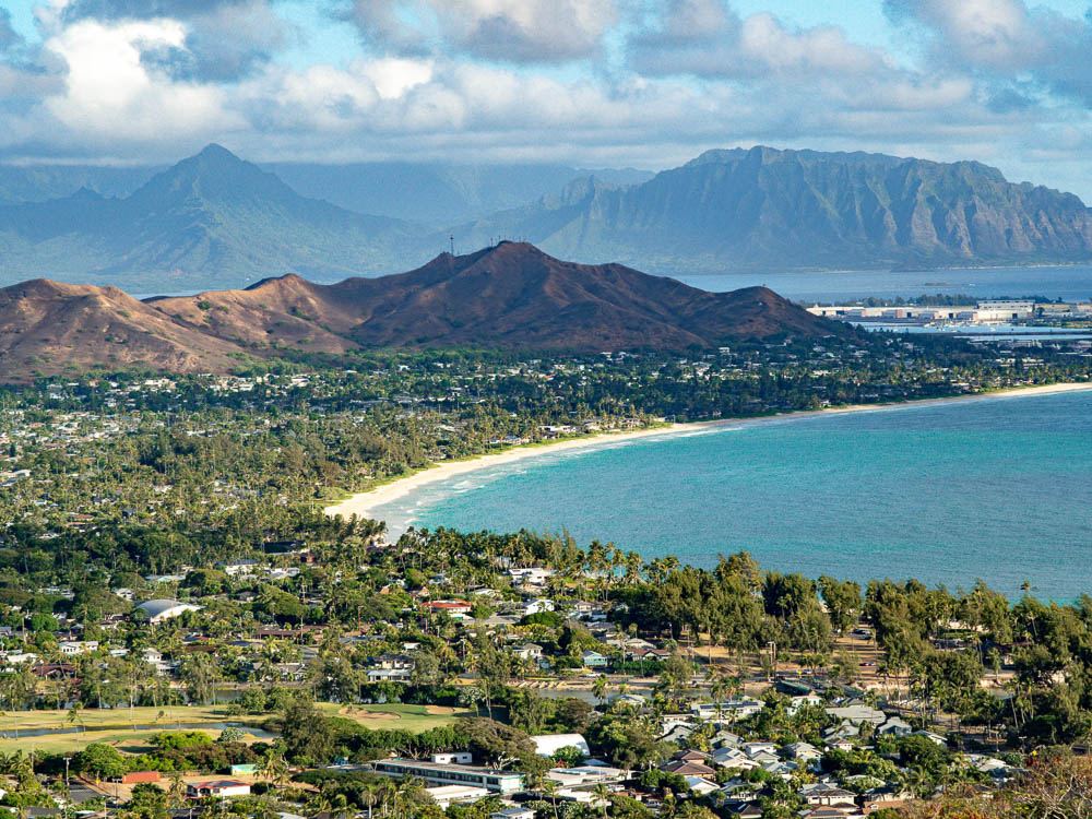 overhead view of a town and beaches with cliffs and mountains in the background