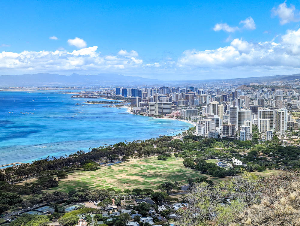 overhead view of honolulu city skyline next to the ocean