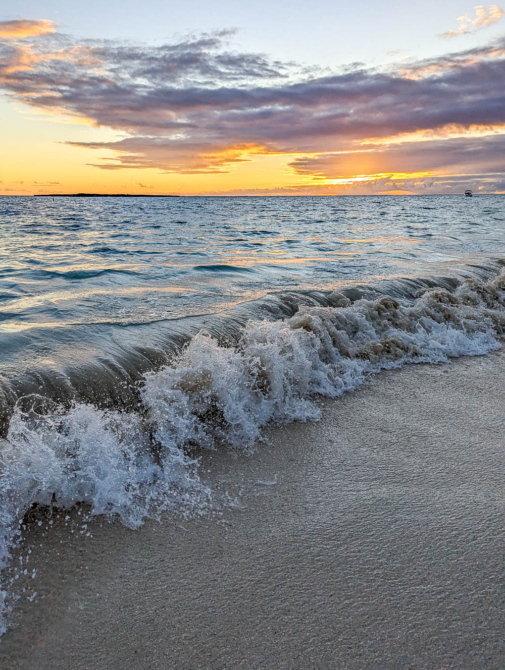 ocean waves at sunrise with a purple and orange sky