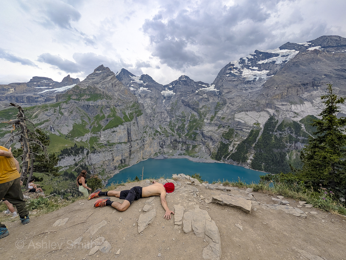 man lying on the edge of a mountain cliff
