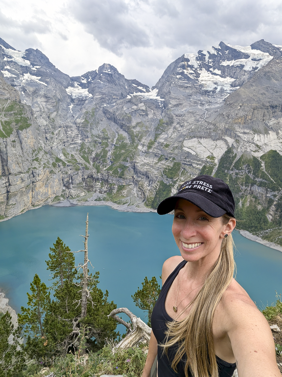 woman taking selfie in front of a turquoise mountain lake