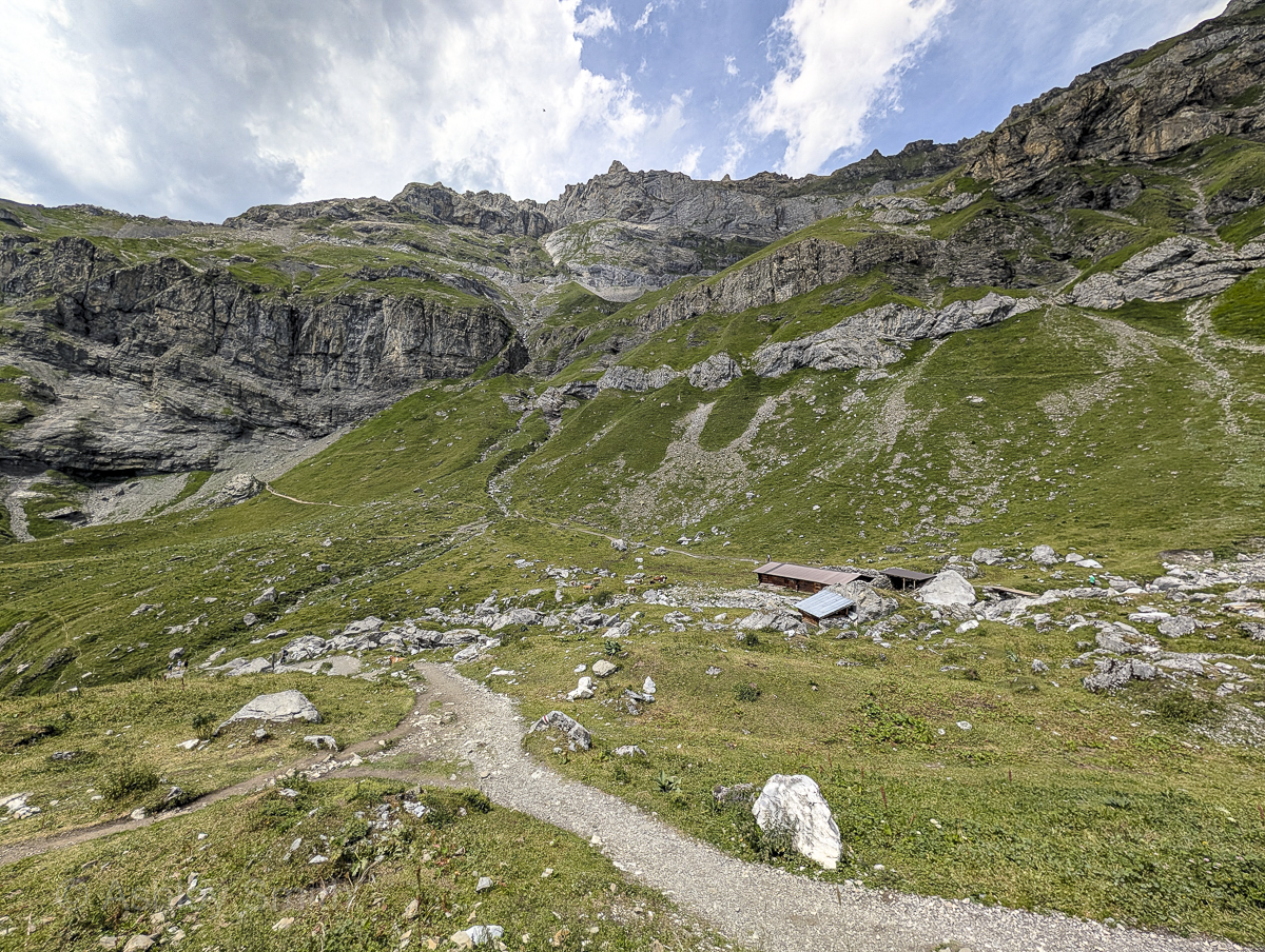 large green meadow surrounded by rocky mountains