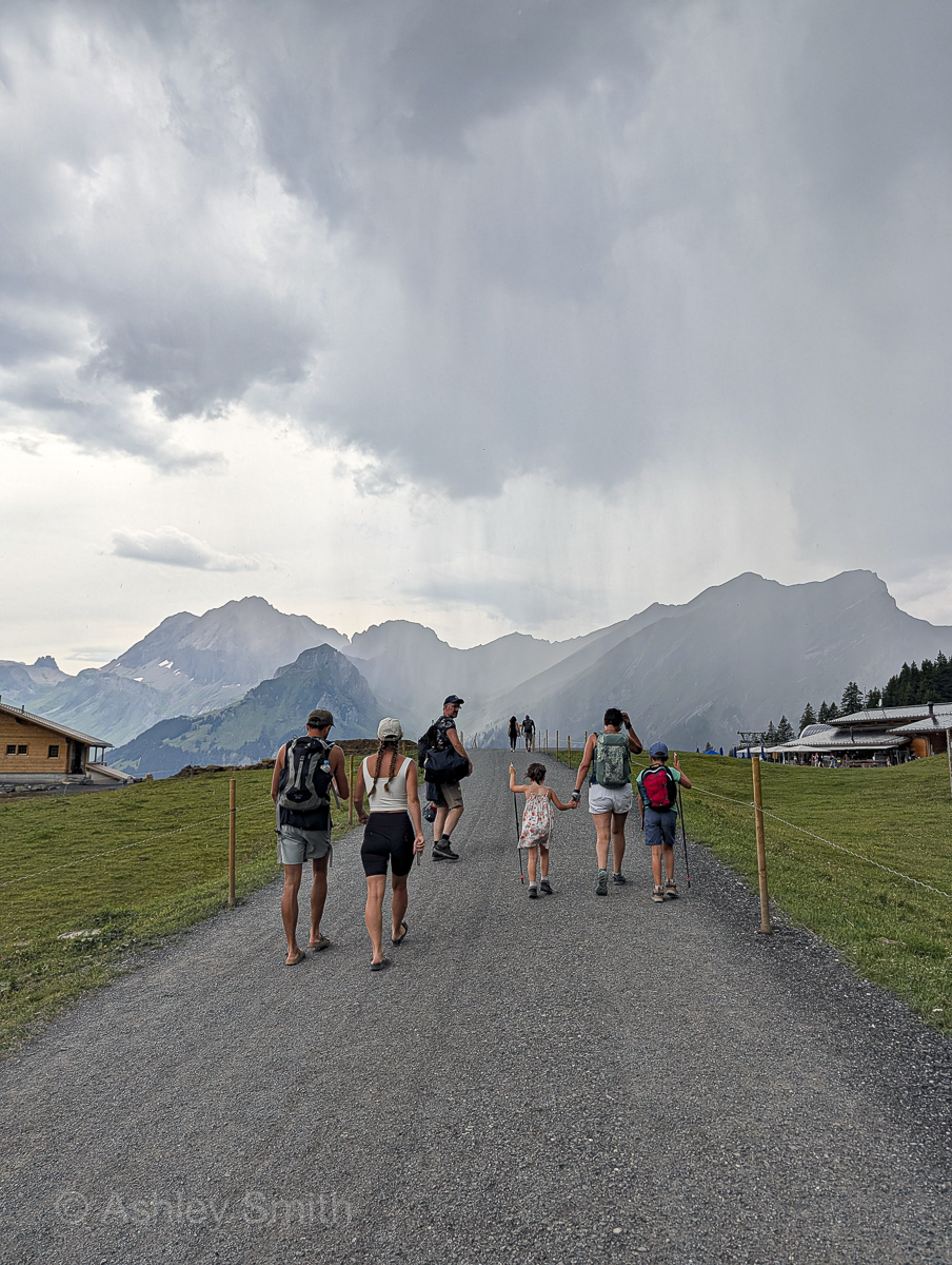 walking on a gravel path with rain clouds in the background