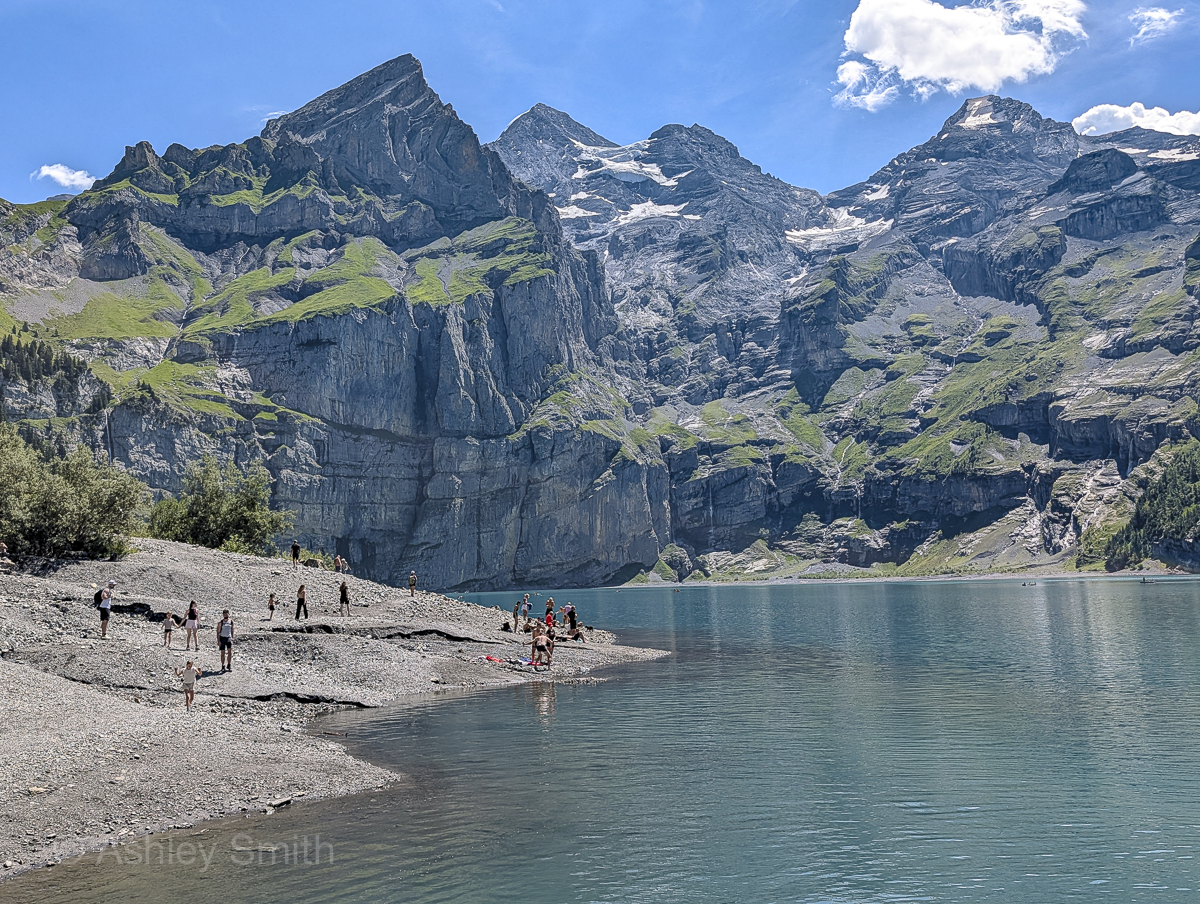 people swimming in a turquoise mountain lake